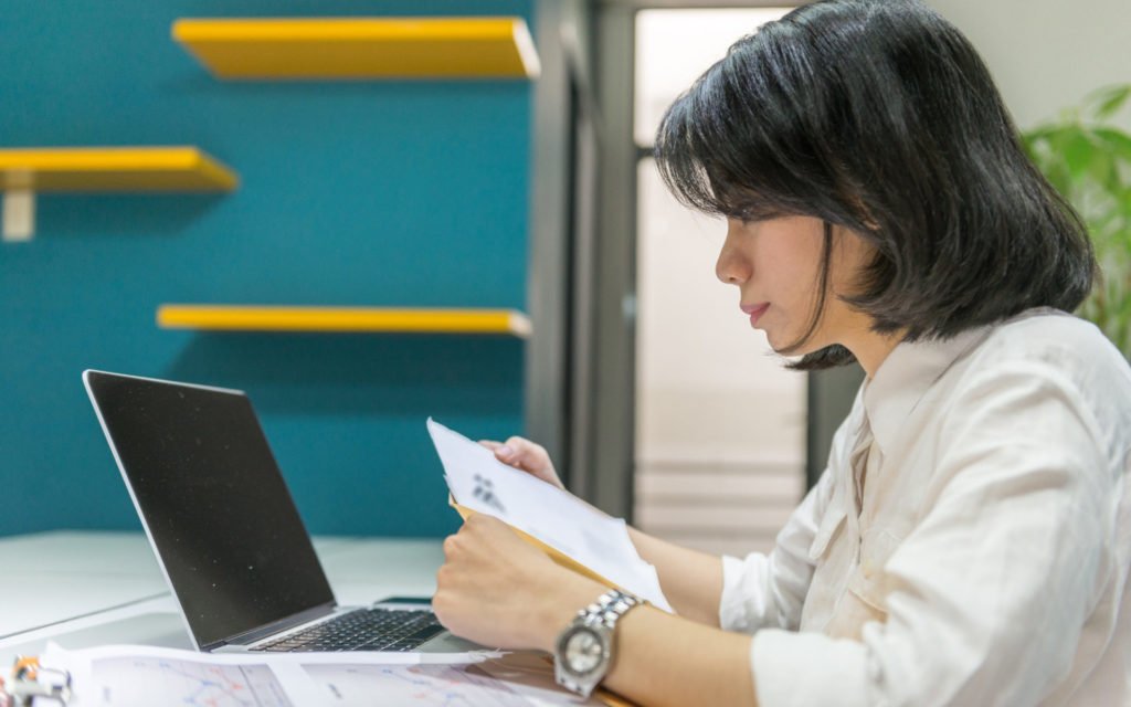 Editor jurnal nasional membaca naskah penelitian dalam bahasa Indonesia di meja kerja